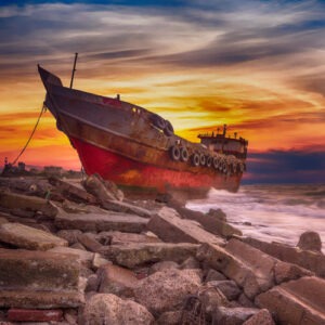 Ein angelegtes Schiff an Wellenbrecher im Sonnenuntergang